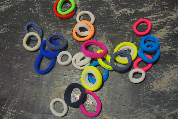 many round, small, colorful hair ties against a black background - Photo, Image