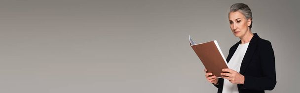 Ώριμος διαχειριστής τυπικής χρήσης σε χάρτινο φάκελο που απομονώνεται σε γκρι, banner  - Φωτογραφία, εικόνα