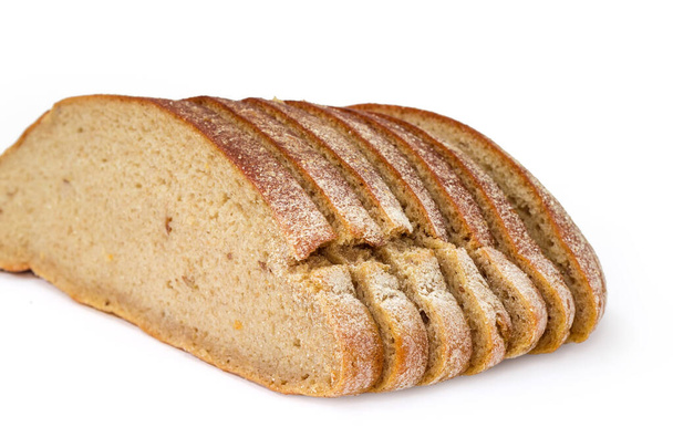 Нарезанный круглый буханка серого хлеба из пшеницы и ржаной муки на белом фоне, крупным планом в селективном фокусе - Фото, изображение