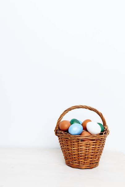 Easter eggs in a wicker basket on a Light background - Foto, Imagen