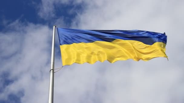 Ukrainan lippu liehuu pilvisellä taivaalla. Suuri keltainen sininen isänmaallinen Ukrainan lippu kansallispäivänä perustuslaki, itsenäisyys, puolustajan päivä. Dnipro kaupunki, Ukraina - Materiaali, video