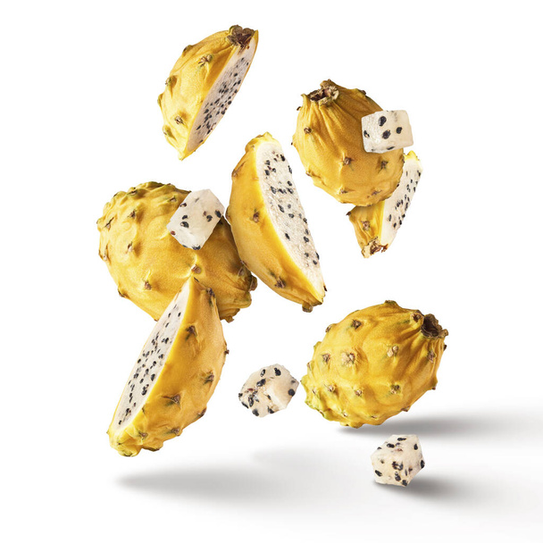 творческий образ со свежими желтыми фруктами дракона или pitaya падая в воздух изолированы на белом фоне., левитации или нулевой гравитации пищевой концепции. Изображение высокого разрешения - Фото, изображение