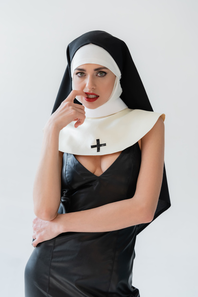seductive nun touching lips while looking at camera isolated on grey - Photo, Image
