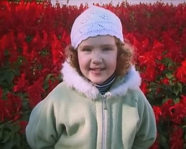 boldog lány nevetett, és mosolygott közelében egy virágágyás közelében - Felvétel, videó