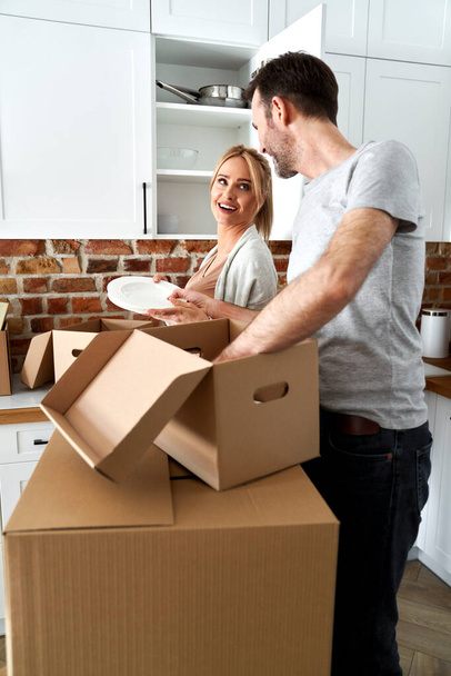Couple pendant un déménagement emballent leurs affaires dans des boîtes en carton                                - Photo, image