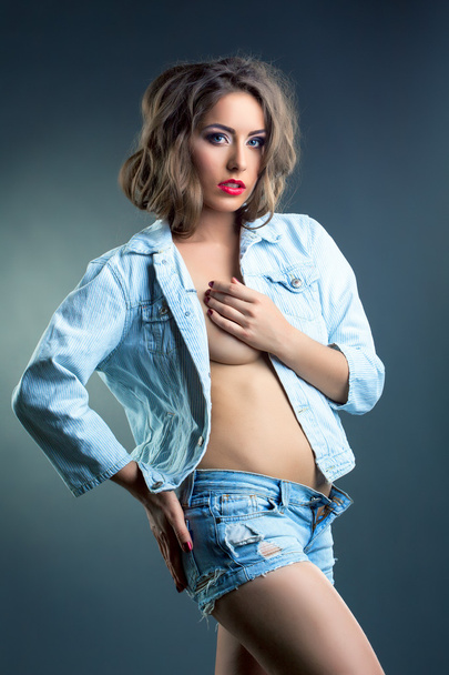beddable jonge vrouw poseren in jeans kleding - Foto, afbeelding