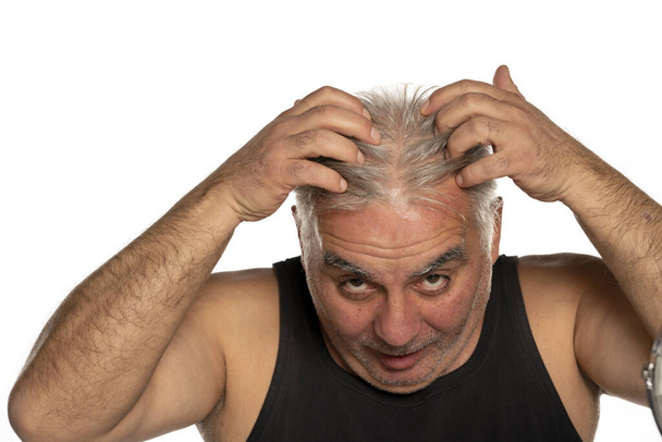 стурбований чоловік середнього віку з коротким сірим волоссям на білому тлі
 - Фото, зображення