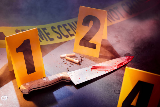 Bloody knife and cigarettes marked with markers at crime scene - Photo, Image
