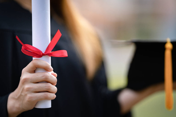Close-up shot of a university graduate holding a degree certification to shows and celebrate education success on the college commencement day. Education stock photo - Photo, Image