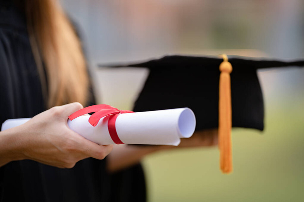 Zbliżenie zdjęcia absolwenta uniwersytetu posiadającego certyfikat ukończenia studiów na pokazy i świętowanie sukcesu edukacji w dniu rozpoczęcia kolegium. Zdjęcie edukacyjne - Zdjęcie, obraz