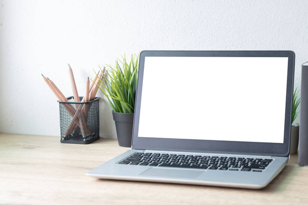 Ноутбук с белым чистым экраном на деревянном столе. Рабочее пространство, рабочее место, концепция рабочего стола. - Фото, изображение