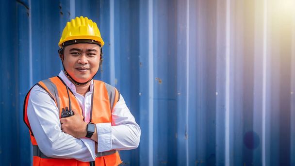Впевнений азіатський портрет інженера-чоловіка в уніформі, що стоїть перед контейнером. Логістика та судноплавство. Професійна професія
. - Фото, зображення