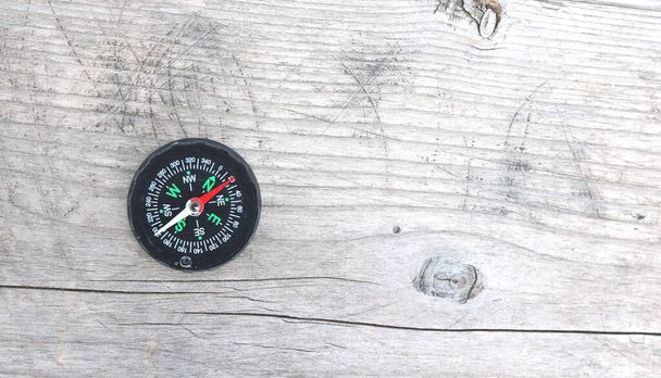 Rundkompass auf natürlichem Holzgrund als Symbol des Tourismus mit Kompass, Reisen mit Kompass und Outdoor-Aktivitäten mit Kompass - Foto, Bild