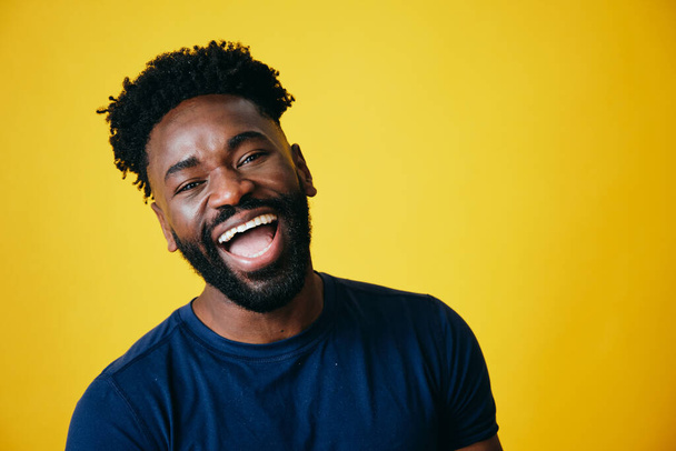 Portré játékos Afro férfi szájjal nyitott sárga háttér - Fotó, kép