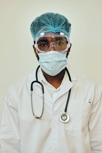 Чоловічий медичний працівник носить захист від коронавірусу на білій стіні в лікарні
 - Фото, зображення