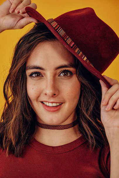 Close up young woman looking at camera with red hat - Foto, imagen