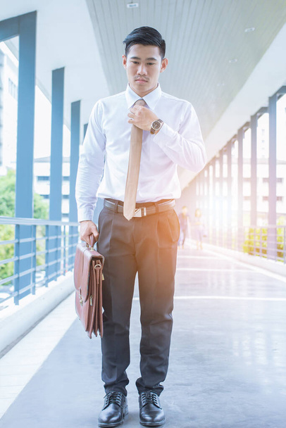 Asian businessman holding brown tie, waiting for appointments, meetings between management - Foto, Imagen