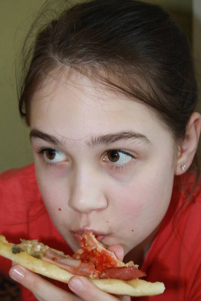 dívka jí pizzababy dívka jí pizzu sedí u stolu - Fotografie, Obrázek