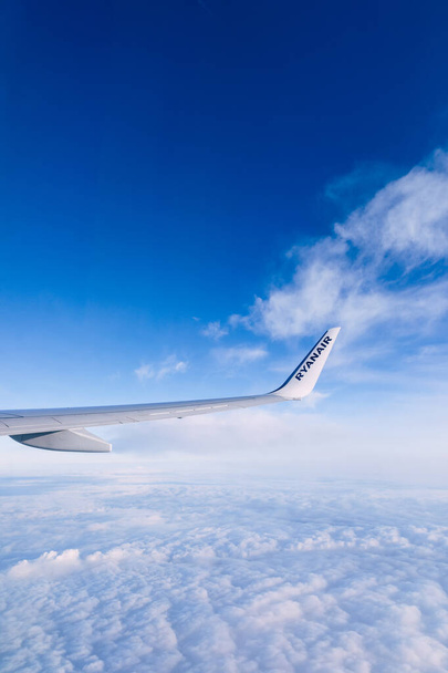 Πτέρυγα αεροπλάνου σε φόντο χρόνου πτήσης γαλάζιου ουρανού. - Φωτογραφία, εικόνα