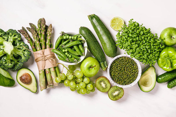 Green vegetables and fruits, greens and legumes on a white background. Healthy food and clean eating concept. Flat lay, top view. - Foto, imagen