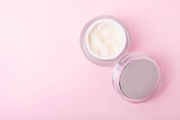 Face cream in a jar on pink background. - Photo, Image