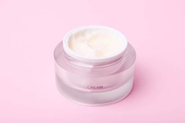 Face cream in a jar on pink background. - Photo, Image