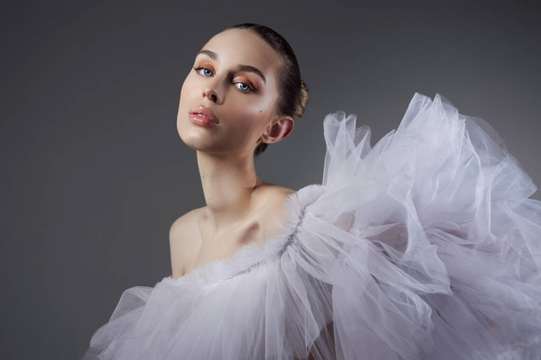 Portrait of a Romantic beauty Woman in light dress. Natural makeup cosmetics, beautiful smooth facial skin, hair pulled back in a bun, art body - Foto, Imagem