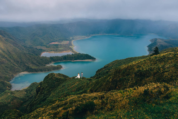 Lagoa do Fogo, a volcanic lake in So Miguel, Azores. A young couple in a suit and dress is walking a beautiful landscape - Photo, Image