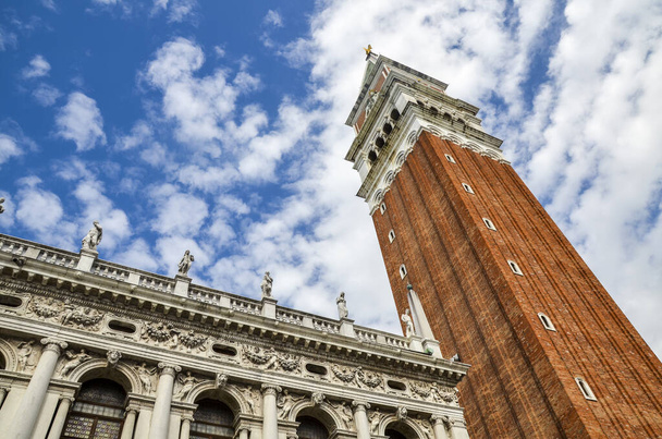 Budynek Biblioteki Narodowej w Marcianie i dzwonnica San Marco, błękitne niebo z chmurami w słoneczny dzień w Wenecji, Włochy - Zdjęcie, obraz