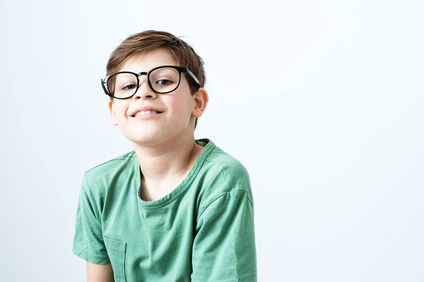 Smiling boy in a green T-shirt and glasses. Copy space - Fotó, kép