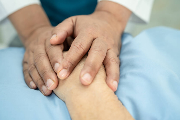 Доктор, який тримає дотик руки азіатська старша або літня жінка пацієнт з любов'ю, турботою, допомогою, заохоченням і емпатією в медперсонал лікарні здорова медична концепція - Фото, зображення