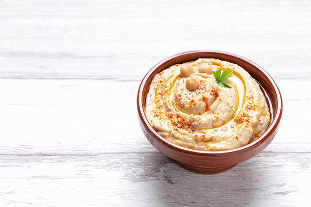 Bowl of homemade hummus isolated on light background with copyspace. - Photo, Image