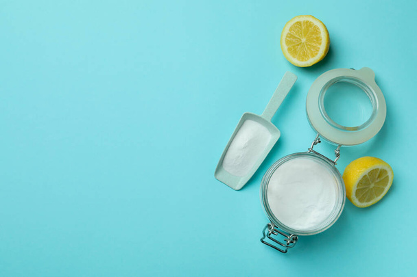 Schaufel und Glas mit Säurepulver und Zitronenhälften auf blauem Hintergrund - Foto, Bild