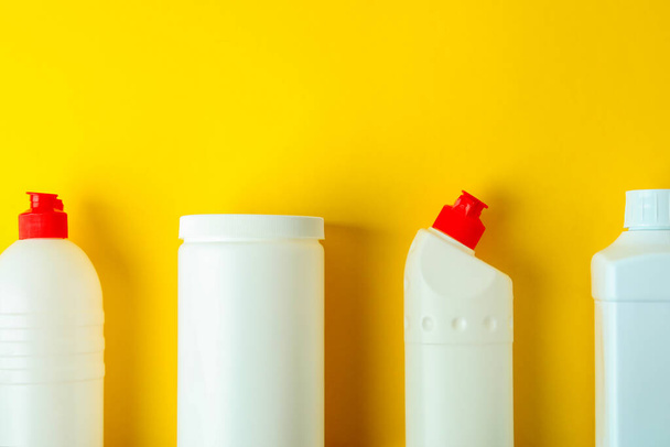 Leere Waschmittelflaschen auf gelbem Hintergrund, Platz für Text - Foto, Bild