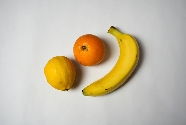 Orange, lemon and banana on white background. - Photo, Image