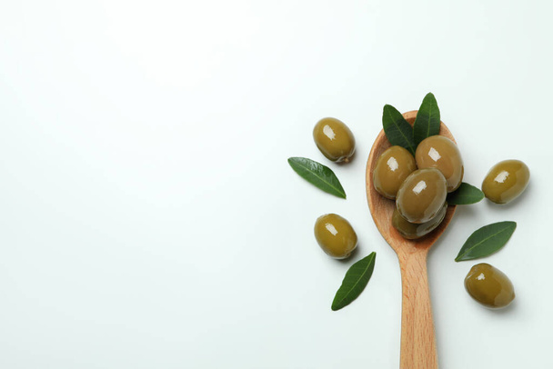 Wooden spoon with olives on white background, space for text - Photo, image