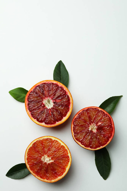 Rote Orangenscheiben mit Blättern auf weißem Hintergrund, Platz für Text - Foto, Bild