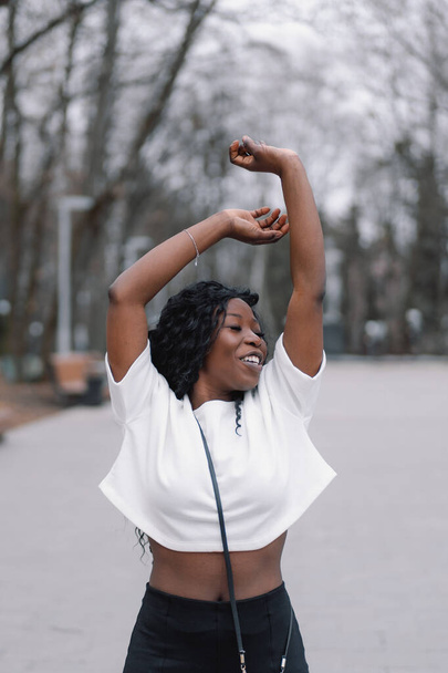 Photo portrait of cheerful black skinned girl. Afro girl dance in city park. Lifestyle - Φωτογραφία, εικόνα