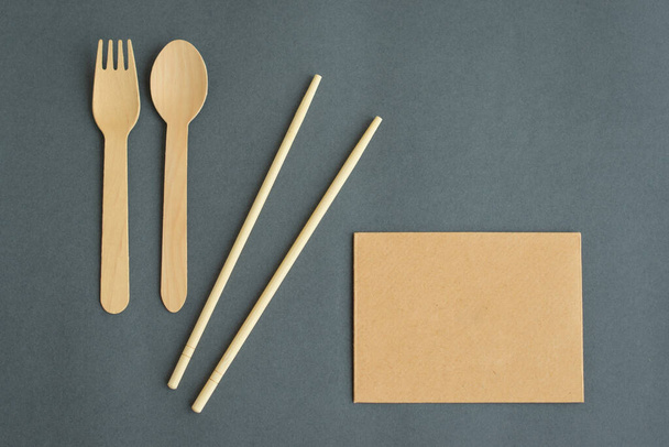 Ekologiczny jednorazowy widelec, łyżka, sushi patyczki na szarym tle. - Zdjęcie, obraz