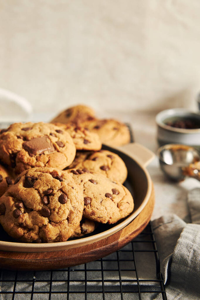 A plate with deliciously baked cookies with chocolate chips on a baking grid - Photo, Image