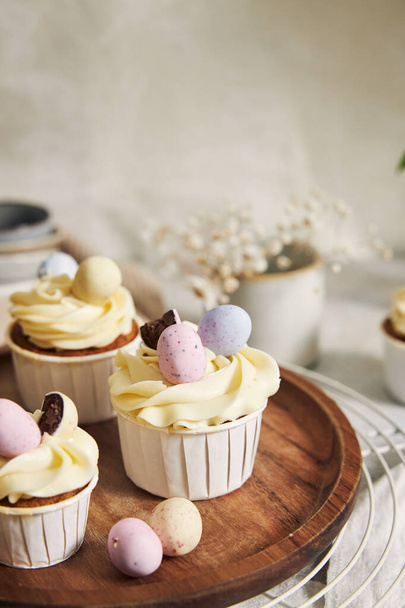 The delicious carrot cupcakes with whipped cream and topping from candies in eggs shape for Easter - Zdjęcie, obraz