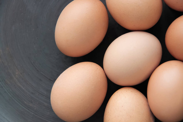Huevos de pollo crudos sin colorear en superficie oscura, vista superior - Foto, Imagen