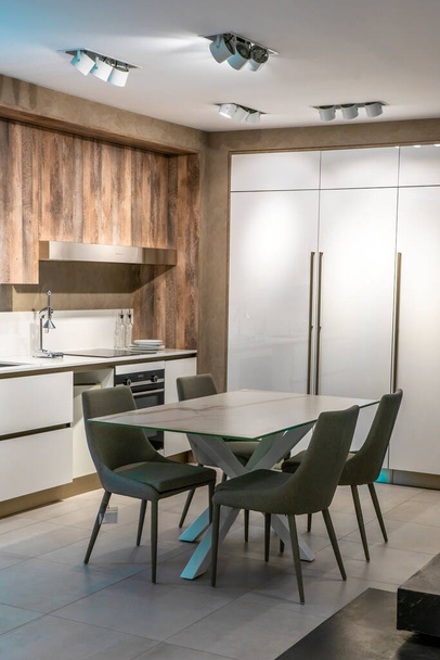 Interior of trendy white minimalistic kitchen with classic wooden details, luxury interior design. Modern pendant lamps, minimalistic interior design concept idea,. High quality photo - Foto, immagini