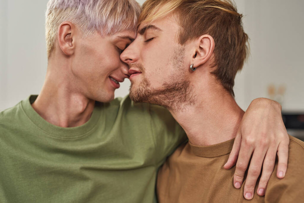 Portrait of tender gay male couple hugging on kitchen - Fotografie, Obrázek