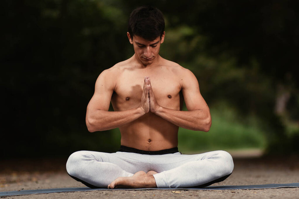 Mladý latinskoamerický muž meditující a cvičící jógu v lese - Fotografie, Obrázek