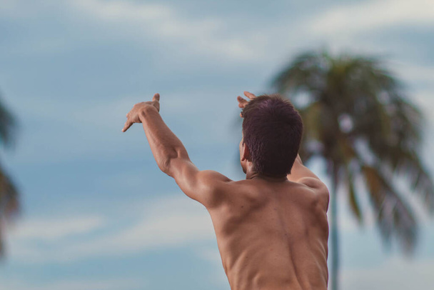 Giovane uomo latino che pratica yoga al tramonto - Foto, immagini