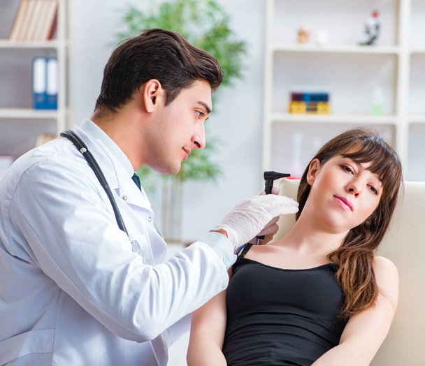Lekarz sprawdzający uszy pacjentów podczas badania lekarskiego - Zdjęcie, obraz