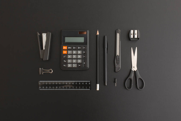 Office and school stationery on black leather background - Photo, image