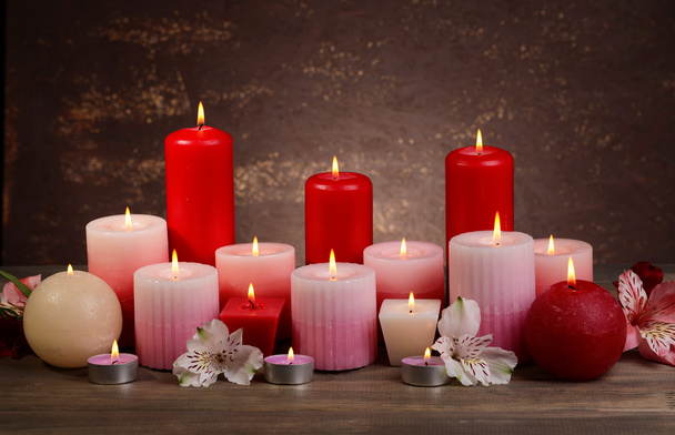 Beautiful candles with flowers on table on brown background - Φωτογραφία, εικόνα