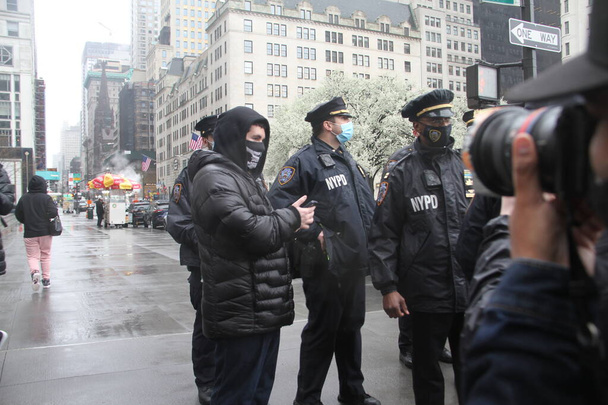 A Nazist White Nationalist Escorted by NYPD During A Protest Against BLM Beside Trump Tower. April 11, 2021, New York , USA: A protest between White Lives Matter and Black Lives Matter on 5th Avenue beside Trump Tower led to NYPD policemen  - Zdjęcie, obraz